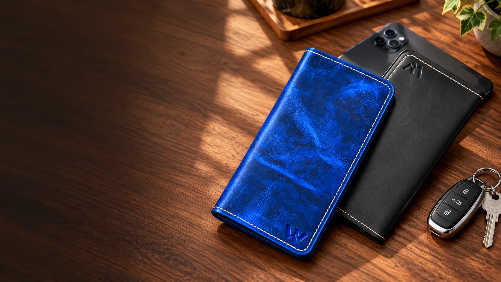 Blue and black Wrenza leather long wallets beside a smartphone and car keys